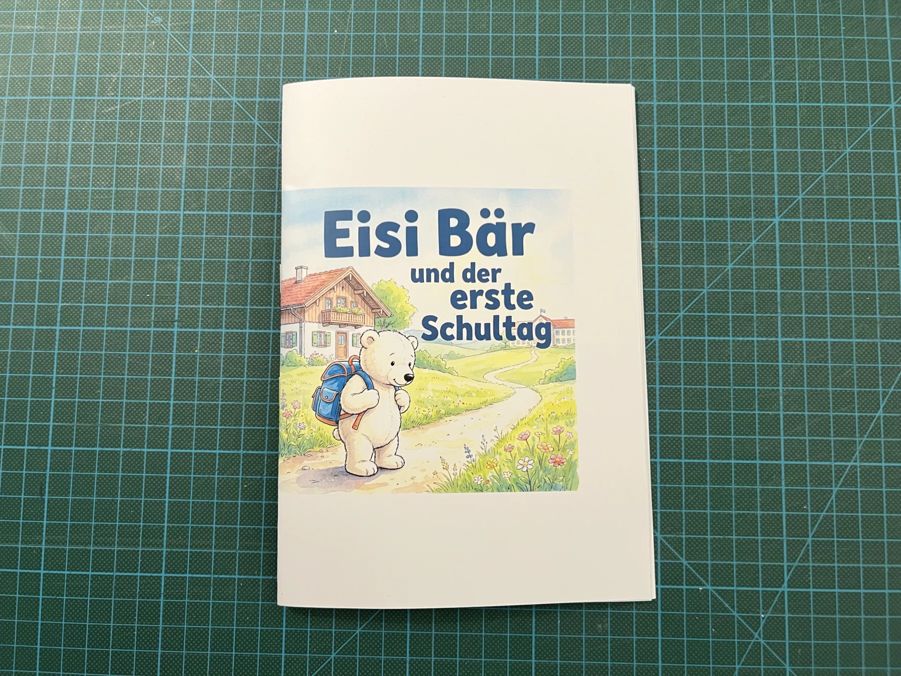 Das fertig gefaltete Büchlein liegt auf der Schneidematte. Rund um das Cover steht noch weißer Rand, der gleich abgeschnitten wird.